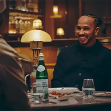 Lewis Hamilton at a restaurant table with S.Pellegrino.