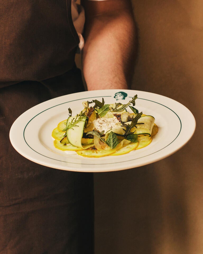 Someone holding a vegetable dish at Lita.