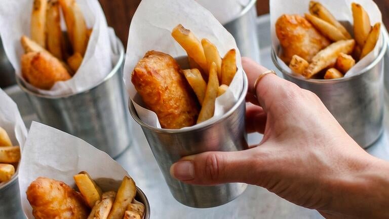 Fish and chips in metal containers.