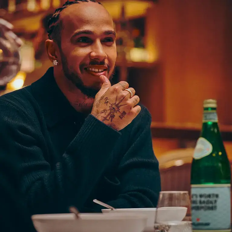 Lewis Hamilton at a restaurant table with S.Pellegrino.