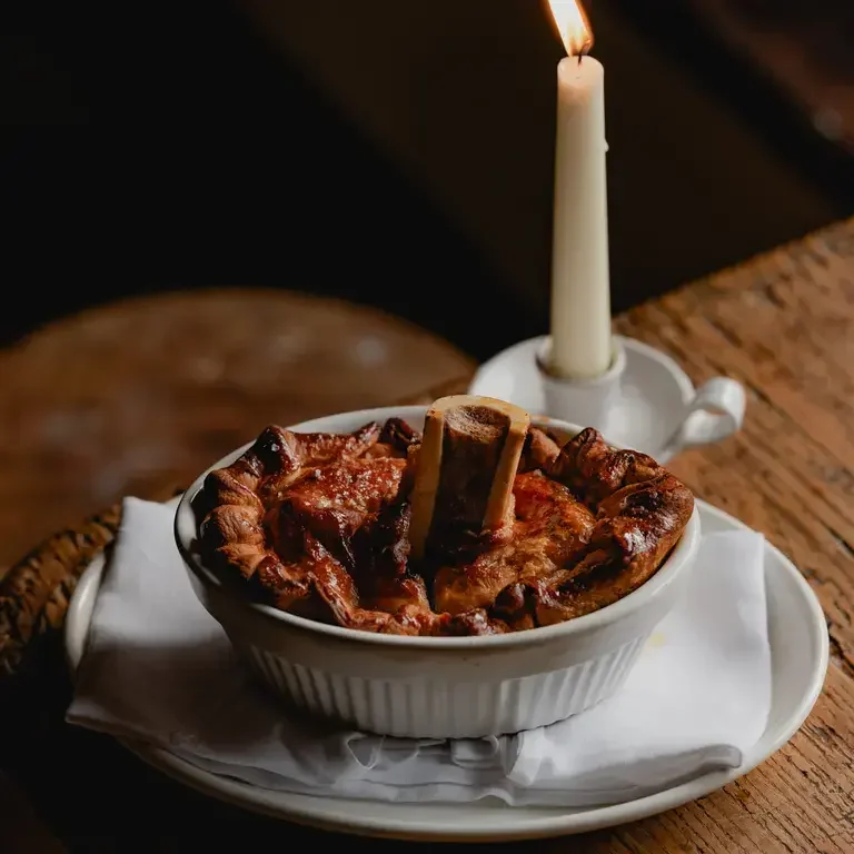 Pie and candle on a table at The Bull Charlbury.