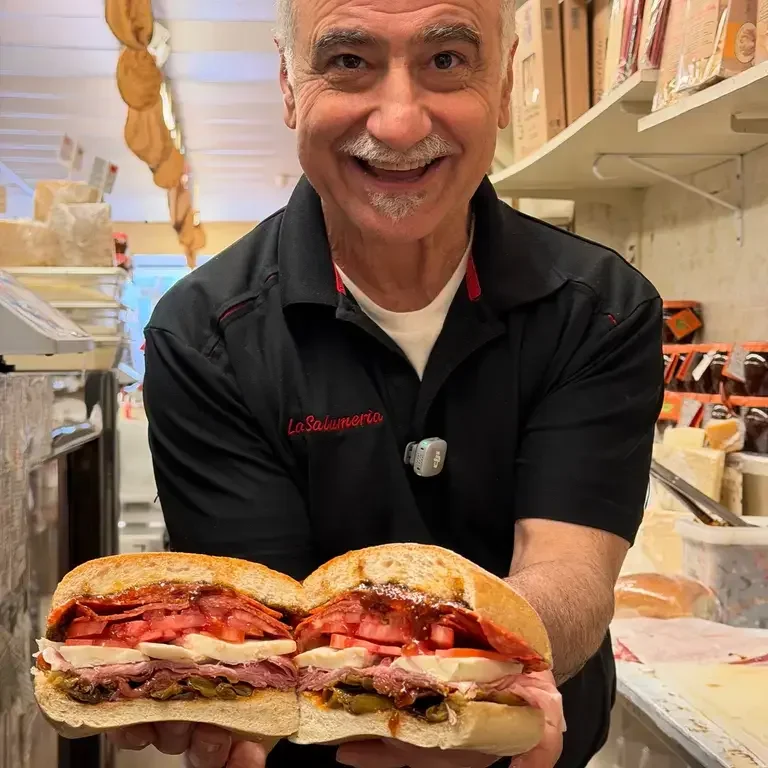 Carlo Celebre holding a sandwich at La Salumeria.