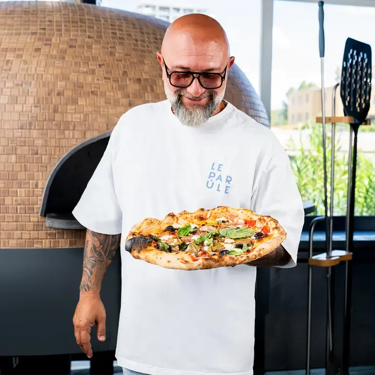 Chef Giuseppe Pignalosa holding a capricciosa.