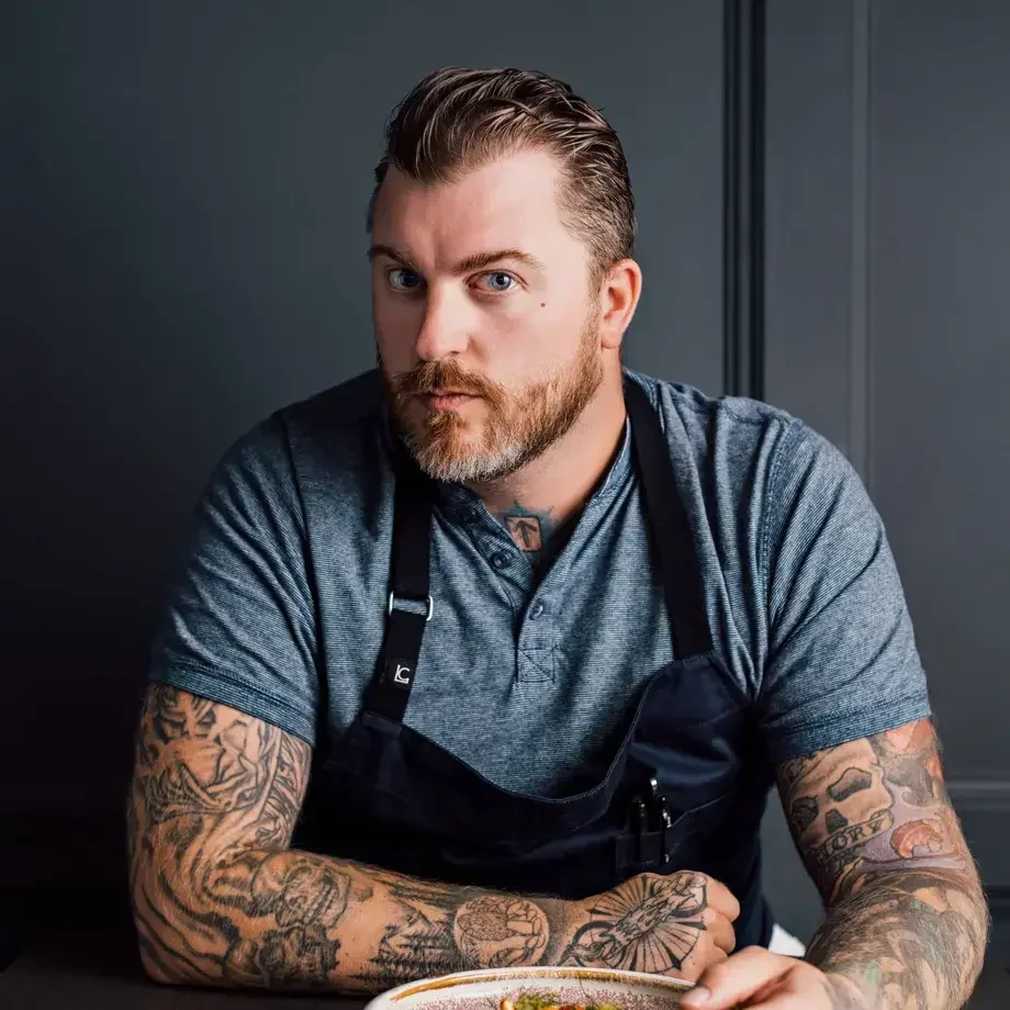 Chef Gus Stieffenhofer-Brandson seated with a plate of food.