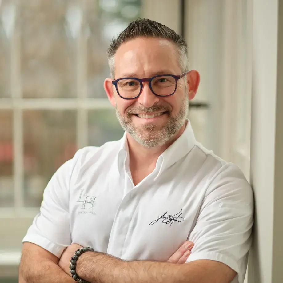 Chef Jason Bangerter, smiling, with his arms folded.
