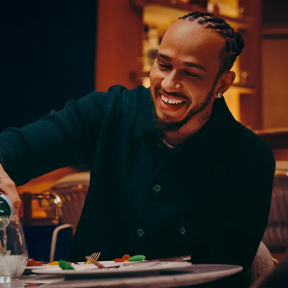 Lewis Hamilton pouring S.Pellegrino into a glass.