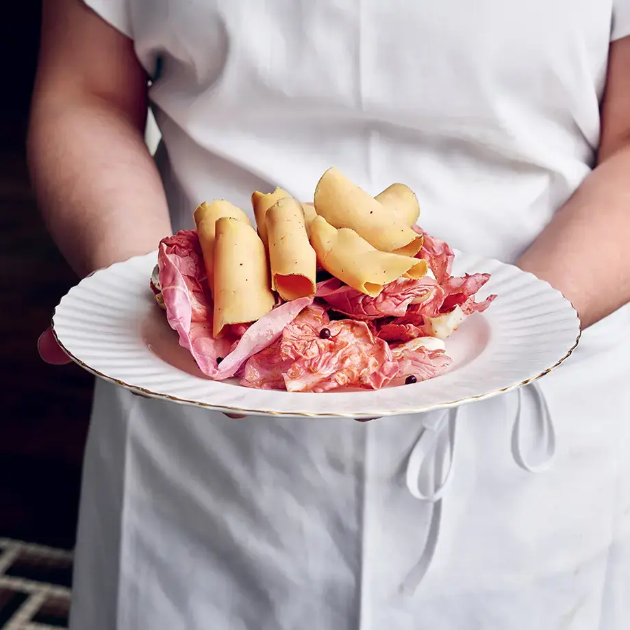 A chef holding a plate of charcuterie at Mon Lapin.