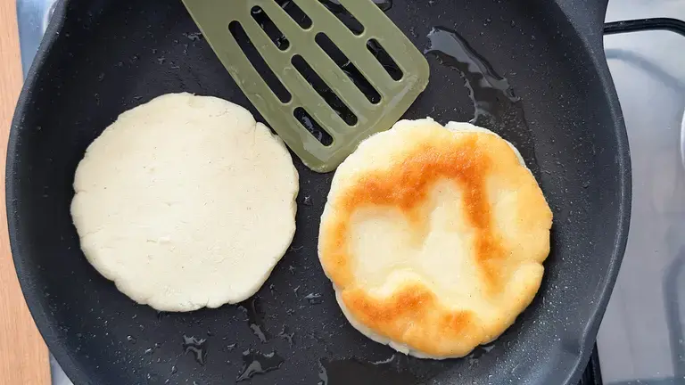 Browning arepas in the pan.