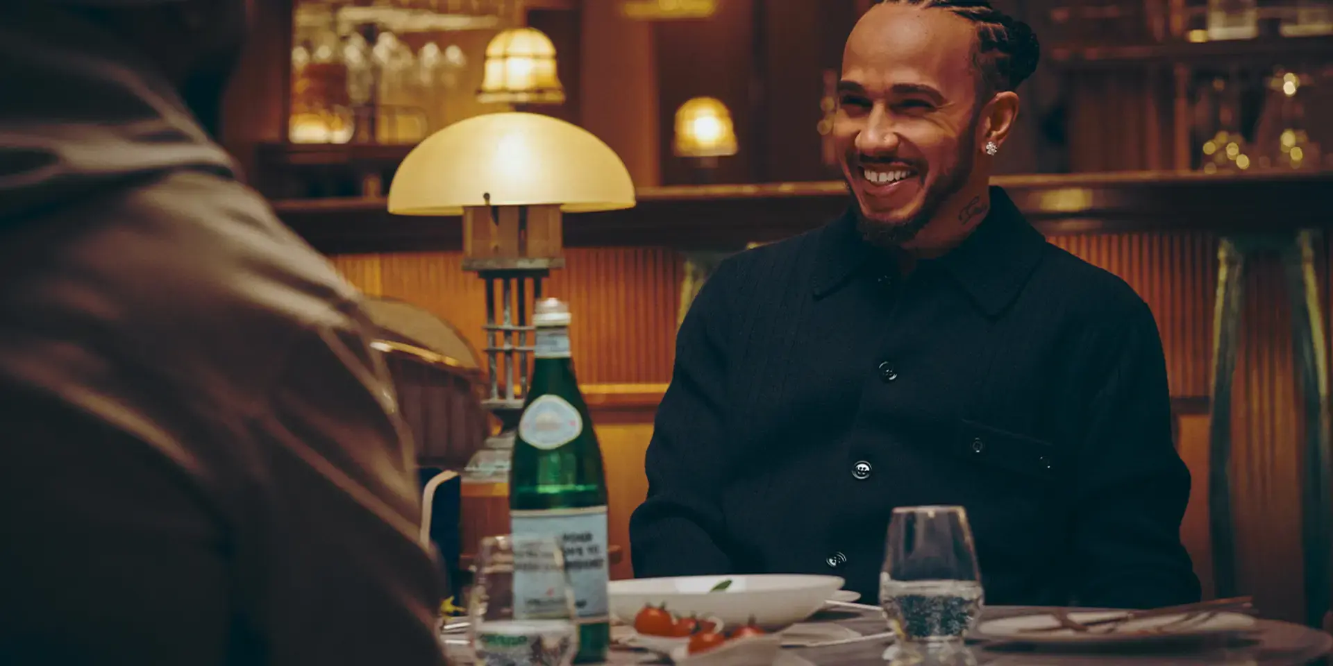 Lewis Hamilton at a restaurant table with S.Pellegrino.