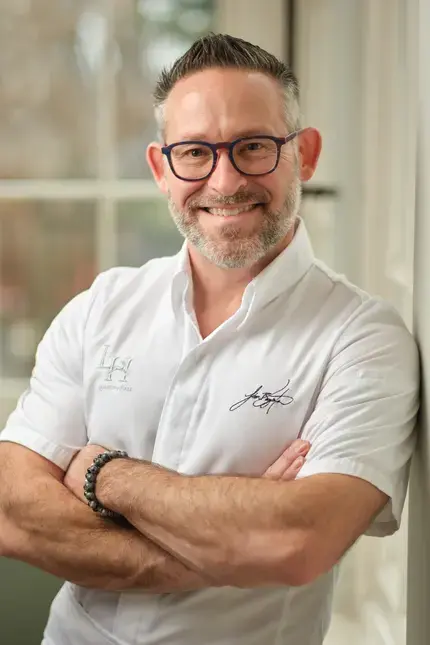 Chef Jason Bangerter, smiling, with his arms folded.