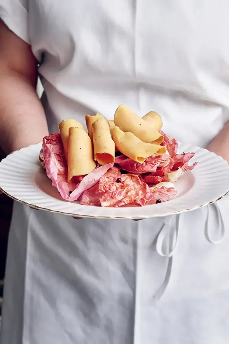 A chef holding a plate of charcuterie at Mon Lapin.
