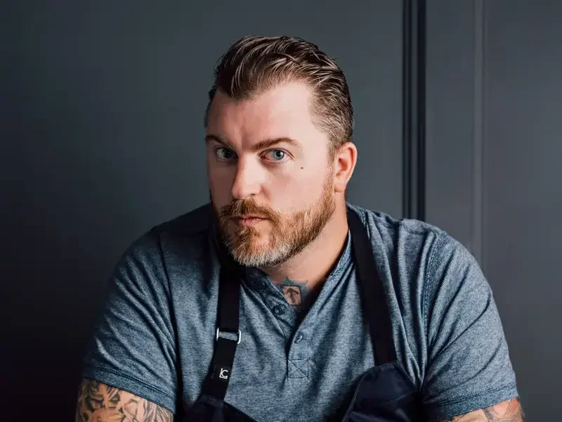 Chef Gus Stieffenhofer-Brandson seated with a plate of food.