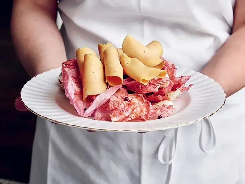 A chef holding a plate of charcuterie at Mon Lapin.