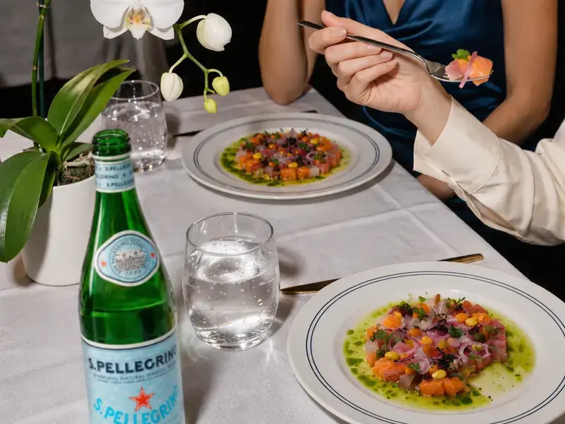 Plates of ceviche on a restaurant table with S.Pellegrino.