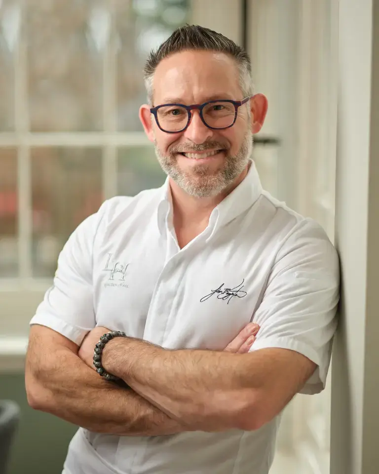 Chef Jason Bangerter, smiling, with his arms folded.
