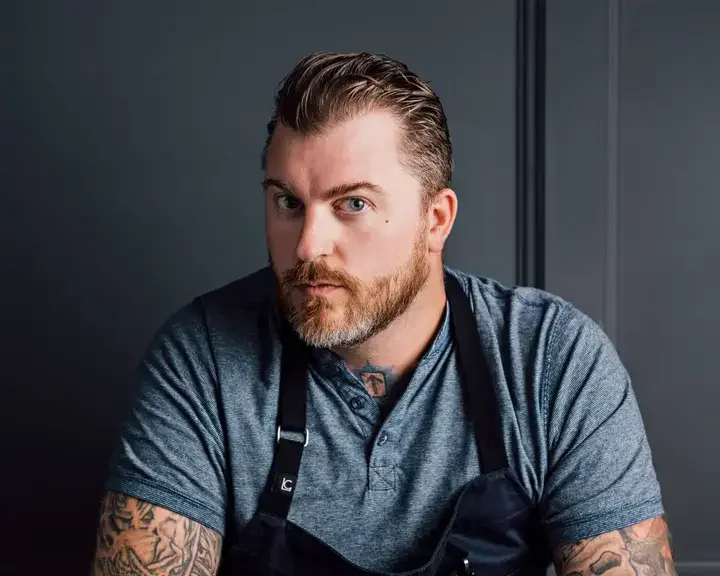Chef Gus Stieffenhofer-Brandson seated with a plate of food.