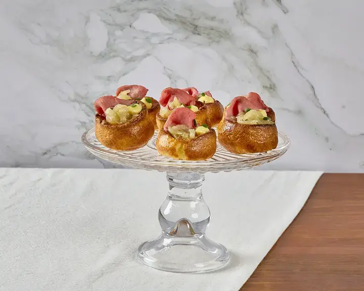Yorkshire pudding bites on a glass platter.