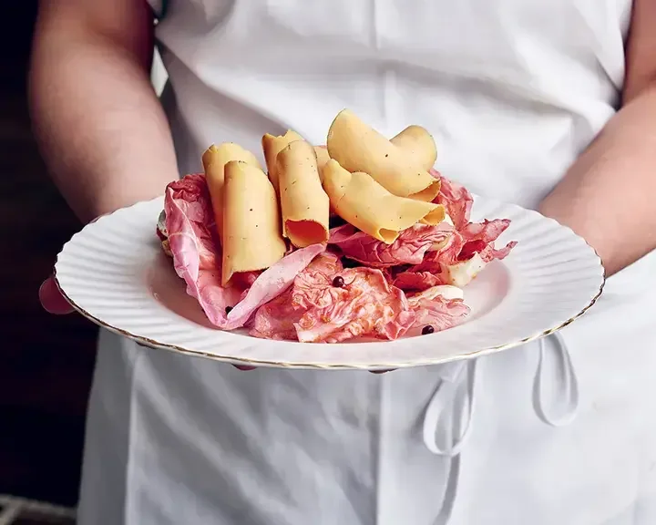 A chef holding a plate of charcuterie at Mon Lapin.